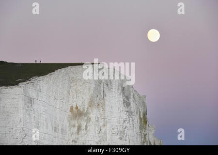 Ein Supermoon steigt über die sieben Schwestern in Sussex, Teil des South Downs National Park im Vereinigten Königreich Stockfoto