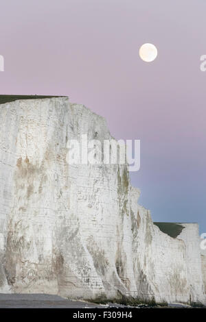 Ein Supermoon steigt über die sieben Schwestern in Sussex, Teil des South Downs National Park im Vereinigten Königreich Stockfoto