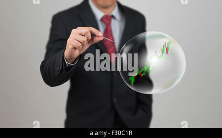 Hand-Loch-Nadel mit Aktien-Chart in der Blase Stockfoto