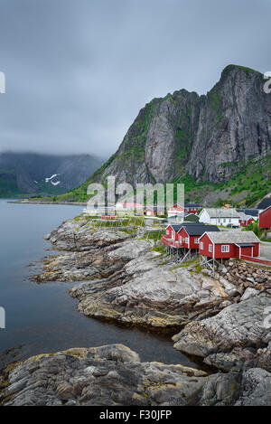 Traditionelle rote Rorbu-Hütten unter Lilandstinden Gipfel in Hamnoy Dorf, Lofoten Inseln, Norwegen. Langzeitbelichtung. Stockfoto