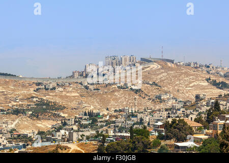 Palästinensischen Dorf und Stadt auf dem Hügel hinter der Trennwand am Westufer in Israel. Stockfoto