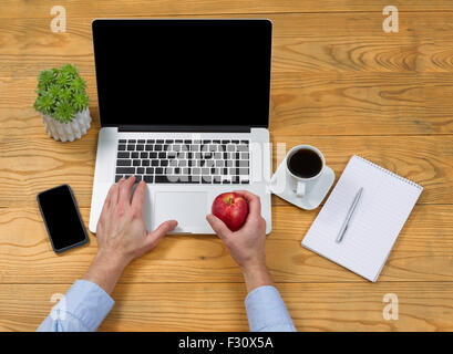 Hoher seitlicher Blick auf männliche Hand, die Apple beim Tippen auf der Computertastatur. Stockfoto