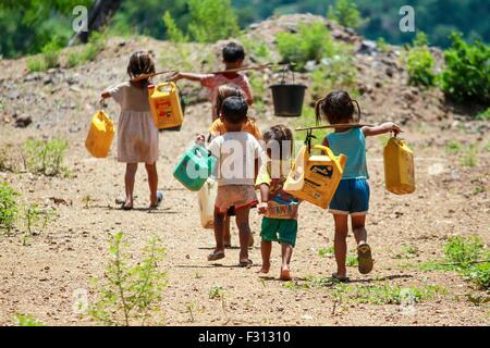 Kinder tragen Wassereimer in Laos. Mangel an fließendes Wasser ist eine bedeutende Entwicklung Ausgabe in der winzigen südostasiatischen Nation. Stockfoto