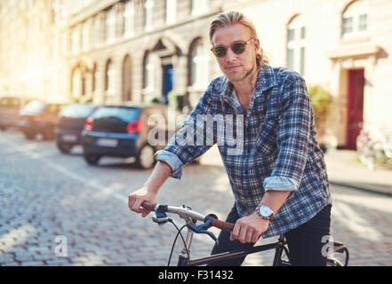 Junger Mann auf seinem Fahrrad in der Stadt, die immer bereit zu reiten Stockfoto