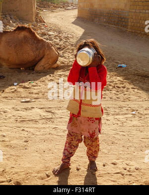 Einen armen indischen Mädchen verstecken Gesicht mit Utensilien in khuri, Jaisalmer, Rajasthan Stockfoto