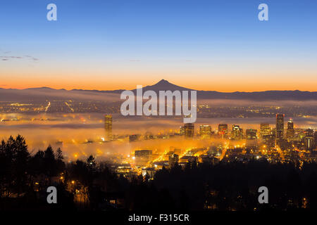 Portland Oregon Innenstadt Stadtbild mit Silhouette of Mount Hood abgedeckt bei geringer Nebel bei Sonnenaufgang Stockfoto