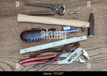 Alte Werkzeuge auf Holztisch. Konzept der Reparatur, Wartung, Instandhaltung oder Reinigung. Alte Vintage-Look. Stockfoto