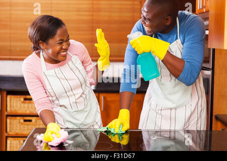 junge afrikanische Paare, die Spaß bei der Hausarbeit Stockfoto