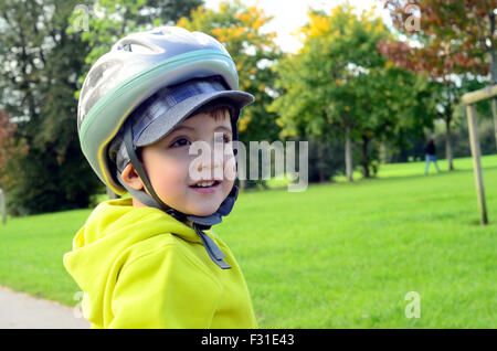 Ein kleiner Junge mit seinem Roller im Park zu spielen. Stockfoto