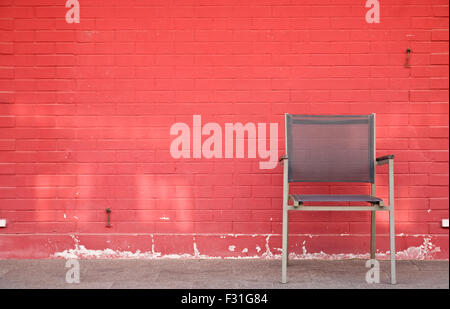 Stuhl und Lampe gegen Mauer Stockfoto