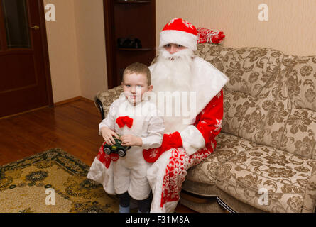 Santa Claus zu Besuch kamen und brachten den jungen ein Geschenk Stockfoto