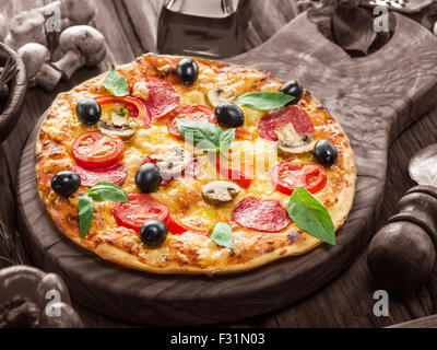 Pizza mit Champignons, Salami und Tomaten. Ansicht von oben. Stockfoto