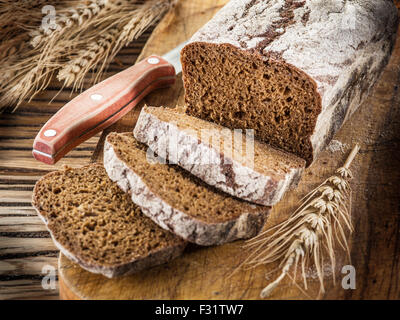 In Scheiben Schwarzbrot auf der alten Holzbrett. Stockfoto