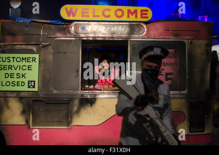 Eiswagen im Banksy Dismaland Verblüffung Park in der Nacht während Abschlussparty mit bewaffneten Polizisten ausgebrannt Stockfoto