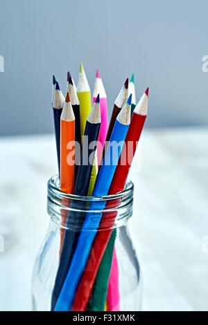 12 Buntstifte in einem Glas Stockfoto