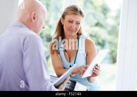 Arzt, die Noten mit Kollegen diskutieren Stockfoto