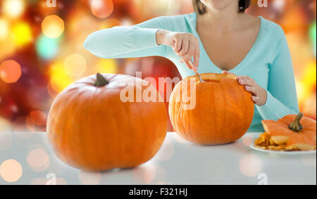 Nahaufnahme von Frau schnitzen Kürbisse für halloween Stockfoto