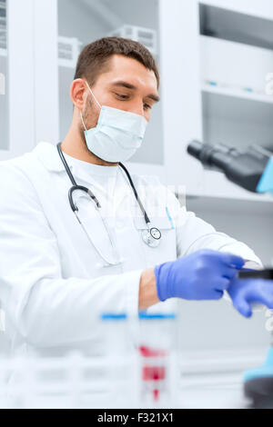 junge männliche Wissenschaftler mit Handschuhen im Labor Stockfoto