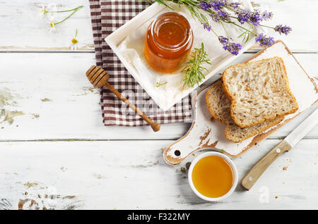 Glas mit Honig und Toast zum Frühstück. Ansicht von oben Stockfoto