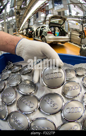 Ingolstadt, Deutschland. 28. Februar 2014. Ein Mitarbeiter hält Audi Emblem vor ein Audi A3 im Audi-Werk in Ingolstadt, Deutschland, 28. Februar 2014. Foto: Armin Weigel/Dpa/Alamy Live-Nachrichten Stockfoto