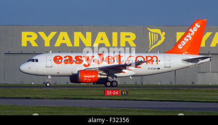 EasyJet Flugzeug G-EZAK, Airbus A319-111 vergeht die Start-und Landebahn am Flughafen Stansted Ryanair hangar Stockfoto