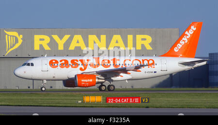 EasyJet Flugzeug G-EZAK, Airbus A319-111 vergeht die Start-und Landebahn am Flughafen Stansted Ryanair hangar Stockfoto