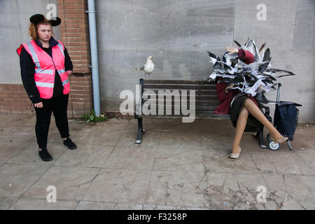 Dame mit Möwen - Kunstwerk von Banksy. Eine müde und schlecht gelaunt Attendant mit schwarzen micky-Mouse-Ohren blickt auf. Stockfoto