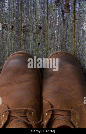 Paar Lederstiefel auf einem Holzfußboden Stockfoto