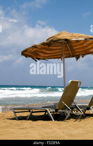 Liegestühle und Sonnenschirm auf Kreta Stockfoto