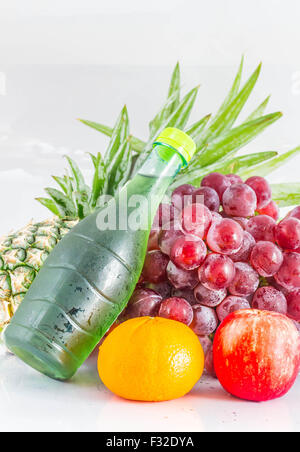 Säfte und viele Früchte auf einem weißen Hintergrund. Stockfoto