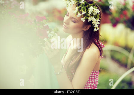 Charmante Frau mit Blumenhut Stockfoto