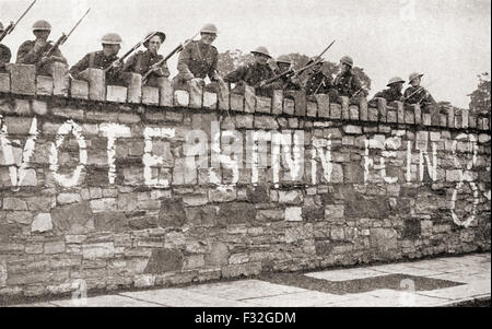 Britische Truppen bewachen eine Wand, die mit einer Sinn Féin Werbung während Irischer Krieg von Unabhängigkeit aka Anglo-Irischer Krieg, im Jahre 1920 verputzt ist. Stockfoto