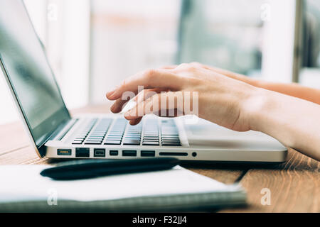 Frau mit Laptop arbeiten auf Holz Schreibtisch platziert Stockfoto