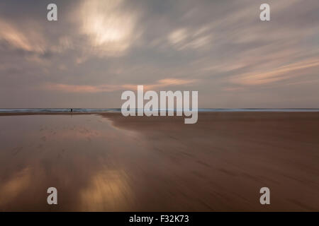 Fußgänger bei Sonnenuntergang, Perranporth, Cornwall, UK Stockfoto