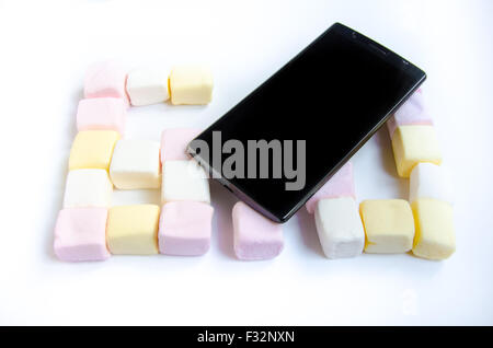 Handy mit farbigen Marshmallows Bonbons Stockfoto