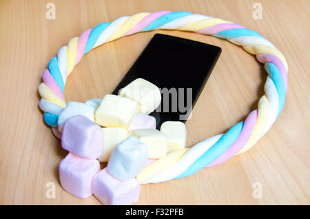 Handy mit farbigen Marshmallows Bonbons Stockfoto