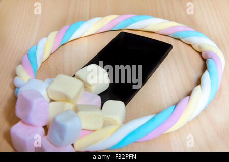 Handy mit farbigen Marshmallows Bonbons Stockfoto