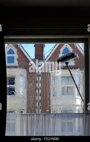 eine Fenster-Reiniger Bürste fegt über die Glasscheibe aus dem Inneren des Raumes gesehen Stockfoto