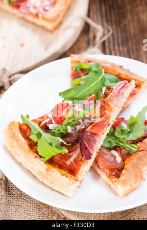 Schinken-Pizza mit Rucola, frischen Tomaten, Knoblauch und Käse Stockfoto