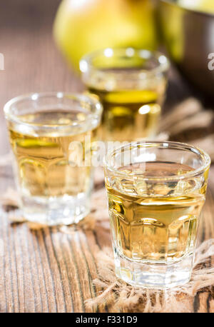 Apfel-Likör Shot (Nahaufnahme) auf dunklem Holz Stockfoto