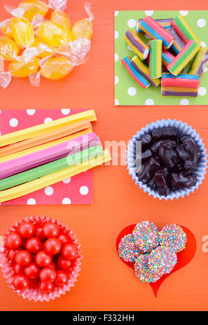 Hellen bunten Süßigkeiten auf orange Holz Hintergrund für Halloween Trick oder Festlichkeit oder Kinder Geburtstag Party gefallen-Tüten. Stockfoto