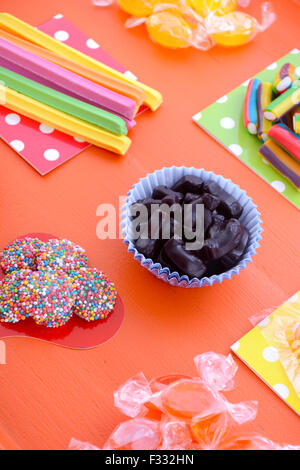 Hellen bunten Süßigkeiten auf orange Holz Hintergrund für Halloween Trick oder Festlichkeit oder Kinder Geburtstag Party gefallen-Tüten. Stockfoto