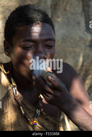 Tansania, Serengeti Plateau, Lake Eyasi Hadzabe Stammes Mann Rauchen von cannabis Stockfoto