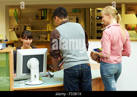 Studenten beim Auschecken Bücher in der Bibliothek Stockfoto