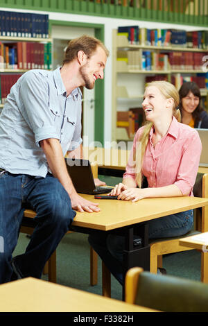 Schüler im Gespräch mit einer Schülerin in Bibliothek Stockfoto