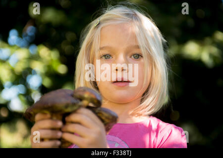 Porträt von Kind blondes Mädchen Abholung Pilze im Wald, machen Spaß, Sommer, Wald, Holz, Wald Stockfoto