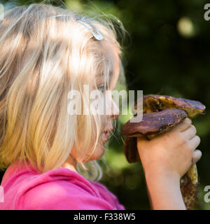 Porträt von Kind blondes Mädchen Abholung Pilze im Wald, machen Spaß, Sommer, Wald, Holz, Wald Stockfoto