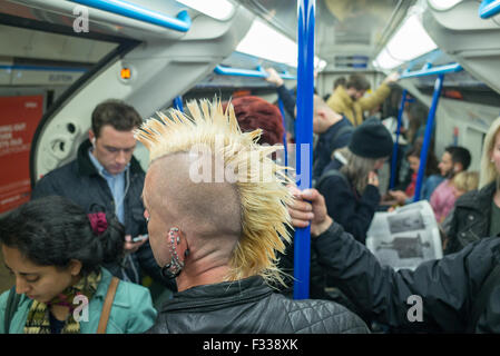 Ein Mann mit einem Irokesenschnitt Haarschnitt auf eine u-Bahn unterirdisch in London Großbritannien Stockfoto