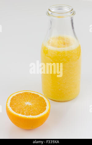 Kiwi und Orange Saft in Glasflaschen isoliert auf weiss. Stockfoto
