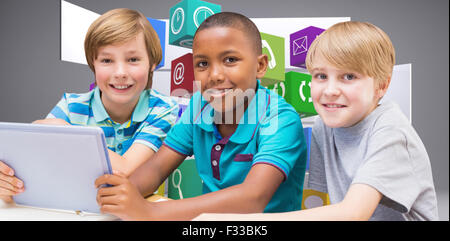 Zusammengesetztes Bild der niedlichen Schülerinnen und Schüler mit Tablet-PC in der Bibliothek Stockfoto